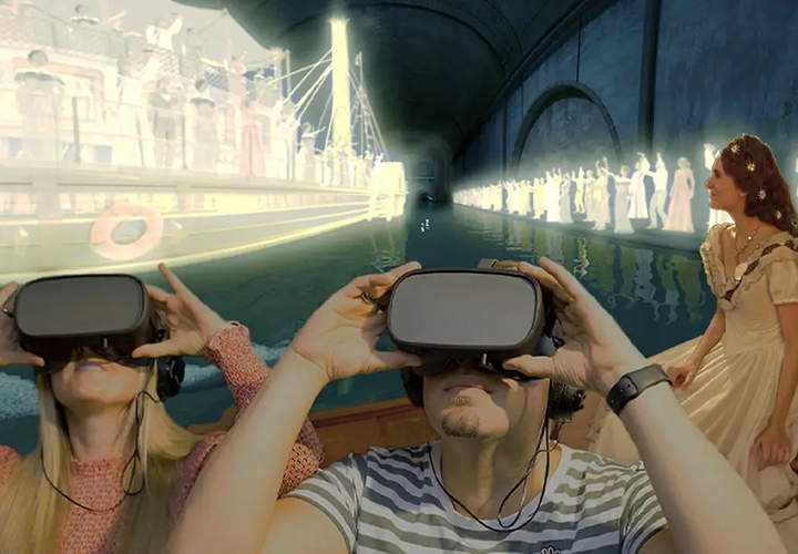 Zwei Personen, die VR-Headsets tragen, scheinen eine virtuelle Szene eines historischen Flussschiffs mit Personen in historischen Kostümen zu erleben, die sich in einem Tunnel mit Wasserspiegelungen befinden. Eine Frau in historischer Kleidung steht in der Nähe.